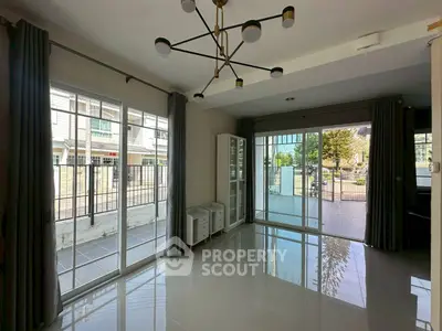 Spacious living room with large windows and modern lighting