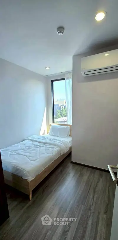 Cozy bedroom with city view and modern air conditioning unit