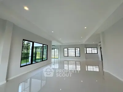 Spacious modern living room with large windows and glossy tile flooring
