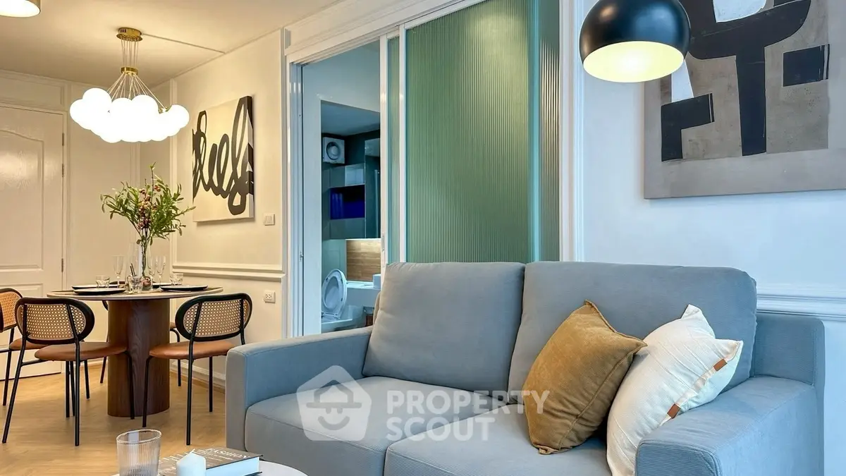 Stylish living room with modern decor and dining area in open layout apartment.