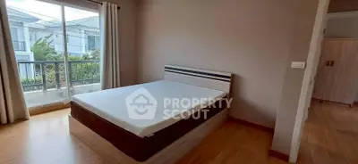 Spacious bedroom with large window and modern decor in a stylish home.