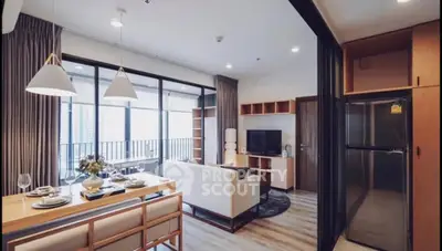 Modern open-plan living room with dining area and balcony access in a stylish apartment.