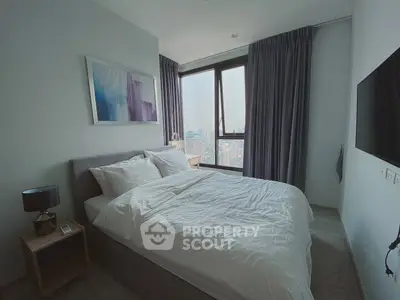Modern bedroom with city view, featuring cozy bed and stylish decor in high-rise apartment.