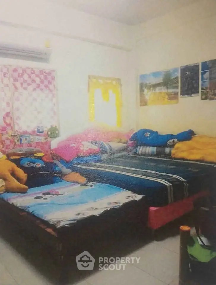 Cozy bedroom with twin beds and colorful decor, perfect for a vibrant living space.