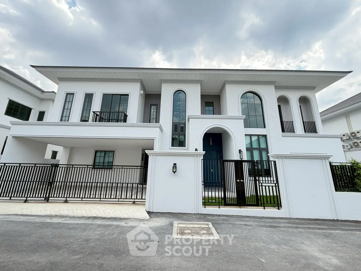 Luxurious modern white villa with elegant arches and large windows, showcasing contemporary architectural design.
