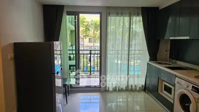 Modern kitchen with balcony view, sleek cabinets, and appliances in a stylish apartment.