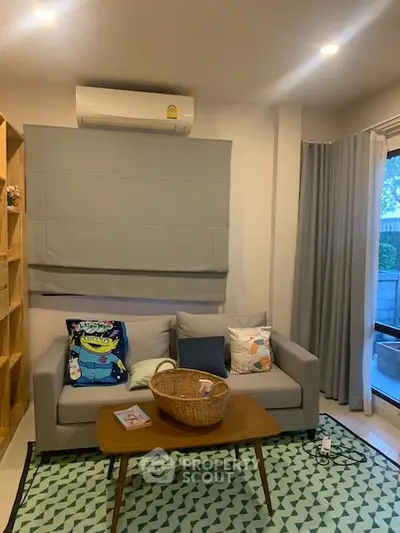 Cozy living room with modern sofa, air conditioning, and stylish decor in a bright apartment.