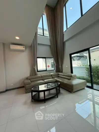 Spacious living room with high ceilings and large windows