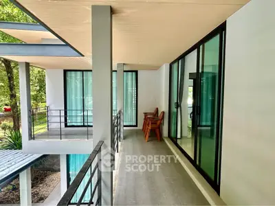 Modern balcony with glass doors and outdoor seating in a contemporary home