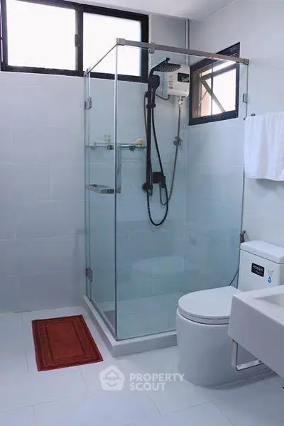 Modern bathroom with glass shower enclosure and sleek fixtures in a contemporary home.