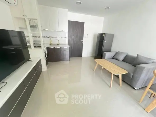 Modern living room with sleek furniture and open kitchen layout in a stylish apartment.