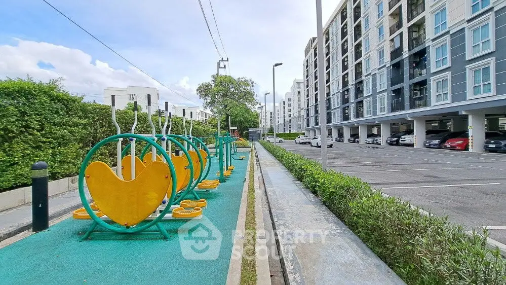 Modern apartment complex with outdoor fitness area and spacious parking lot.