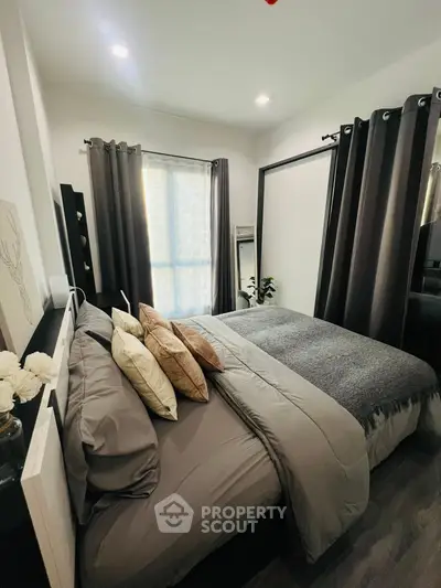 Cozy modern bedroom with stylish decor and ample natural light.