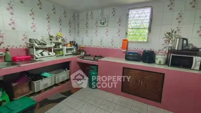 Charming kitchen with pink tile accents and modern appliances, perfect for culinary enthusiasts.