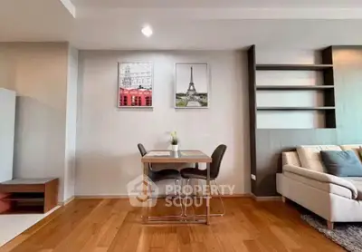 Modern living room with stylish decor and wooden flooring, featuring a cozy dining area and elegant wall art.