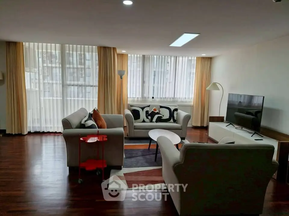 Spacious living room with modern furniture and large windows in a stylish apartment.