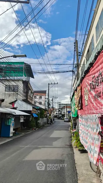 Charming urban street view with vibrant storefronts and clear blue sky, showcasing local architecture and community vibe.