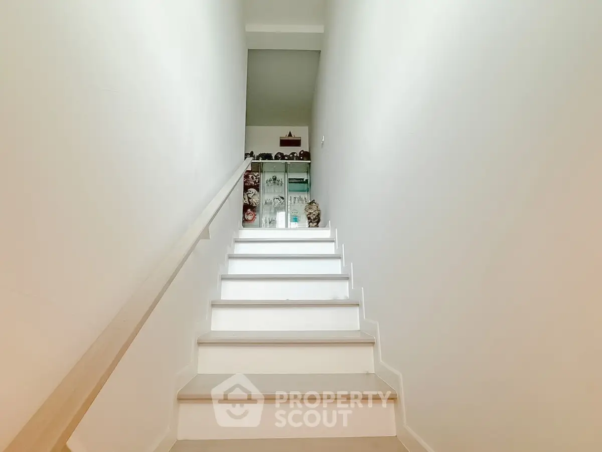 Bright staircase with modern design and decorative elements leading to upper floor.