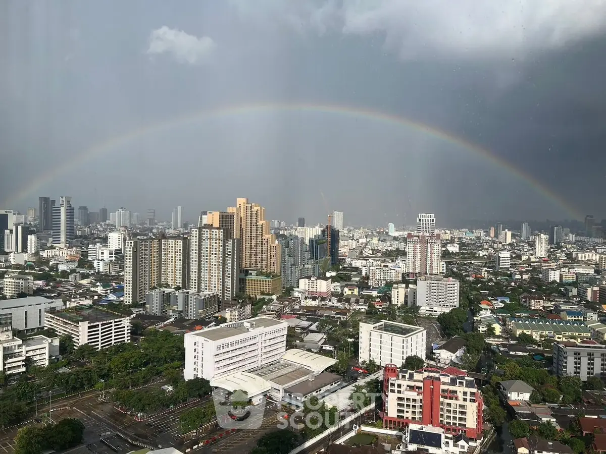 Stunning cityscape view with rainbow over urban skyline, perfect for high-rise living enthusiasts.