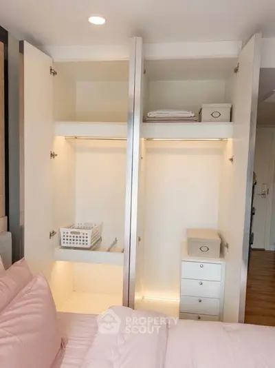Spacious bedroom with open wardrobe showcasing ample storage space and modern design.