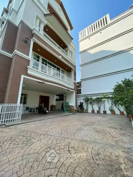 Elegant multi-story building with spacious driveway and modern design.