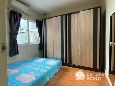 Cozy bedroom with polished wooden flooring, large wardrobe, and air conditioning, perfect for comfortable urban living.