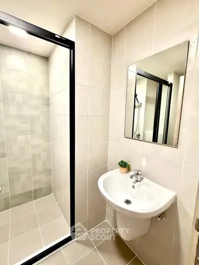 Modern bathroom with sleek shower and stylish sink in contemporary apartment.