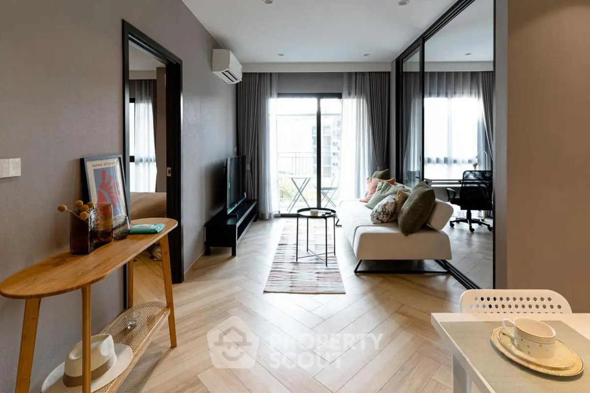 Modern living room with stylish decor and balcony view in a contemporary apartment.