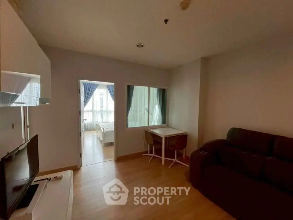 Cozy living room with modern furniture and view into a bright bedroom, perfect for urban living.