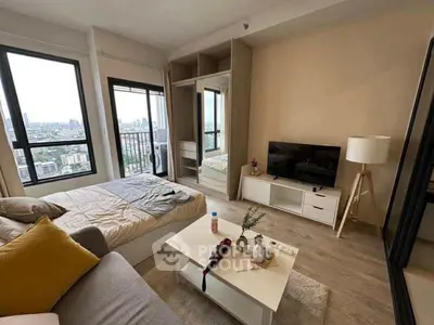 Modern bedroom with city view, cozy decor, and ample natural light.