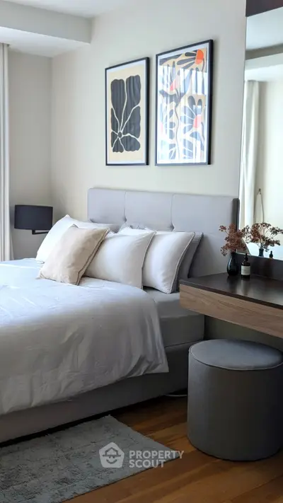 Modern bedroom with stylish decor and cozy ambiance, featuring elegant artwork and plush bedding.