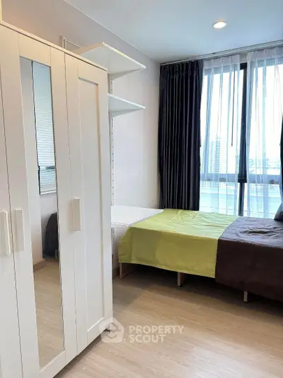 Modern bedroom with large window and stylish wardrobe in urban apartment