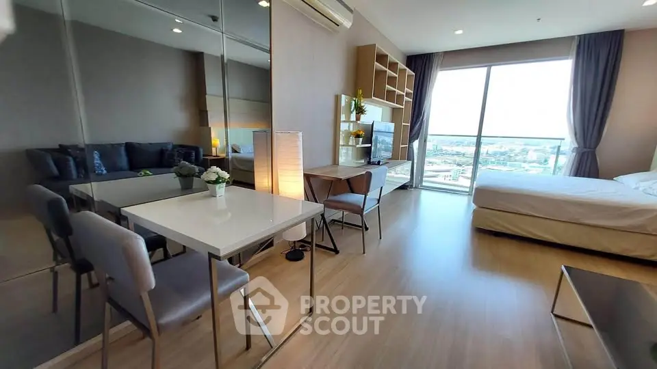 Modern studio apartment with large windows and stylish furnishings
