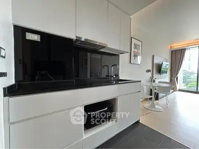 Modern kitchen with sleek black countertops and open layout in stylish apartment