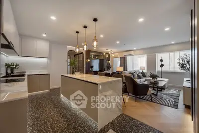 Luxurious open-plan kitchen and living room with modern lighting and elegant decor.