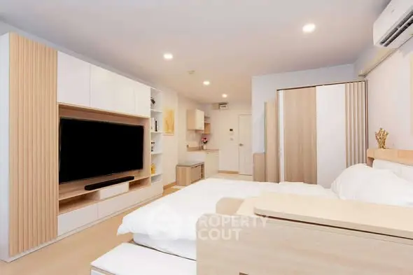 Modern studio apartment with sleek design and integrated storage solutions.