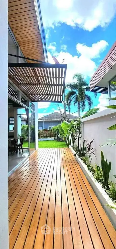 Stunning modern patio with wooden deck and lush garden view, perfect for outdoor relaxation.