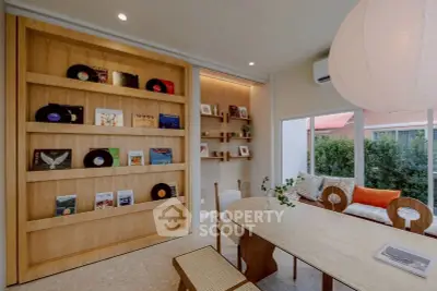 Stylish modern living room with wooden shelves, cozy seating, and large window view.