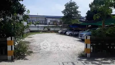 Spacious outdoor parking area with multiple cars and shaded spots, ideal for residential or commercial use.