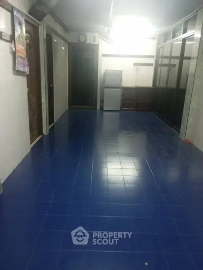 Spacious hallway with blue tiled floor and modern appliances