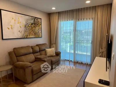 Cozy living room with plush sofa, elegant curtains, and modern wall art in a bright apartment.