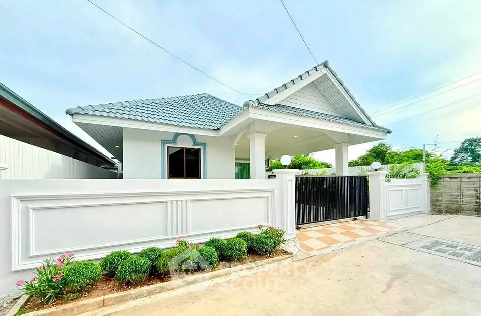 Charming single-story house with blue-tiled roof and white fence, perfect for family living.