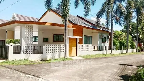 Charming modern house with palm trees and spacious driveway in a serene neighborhood.