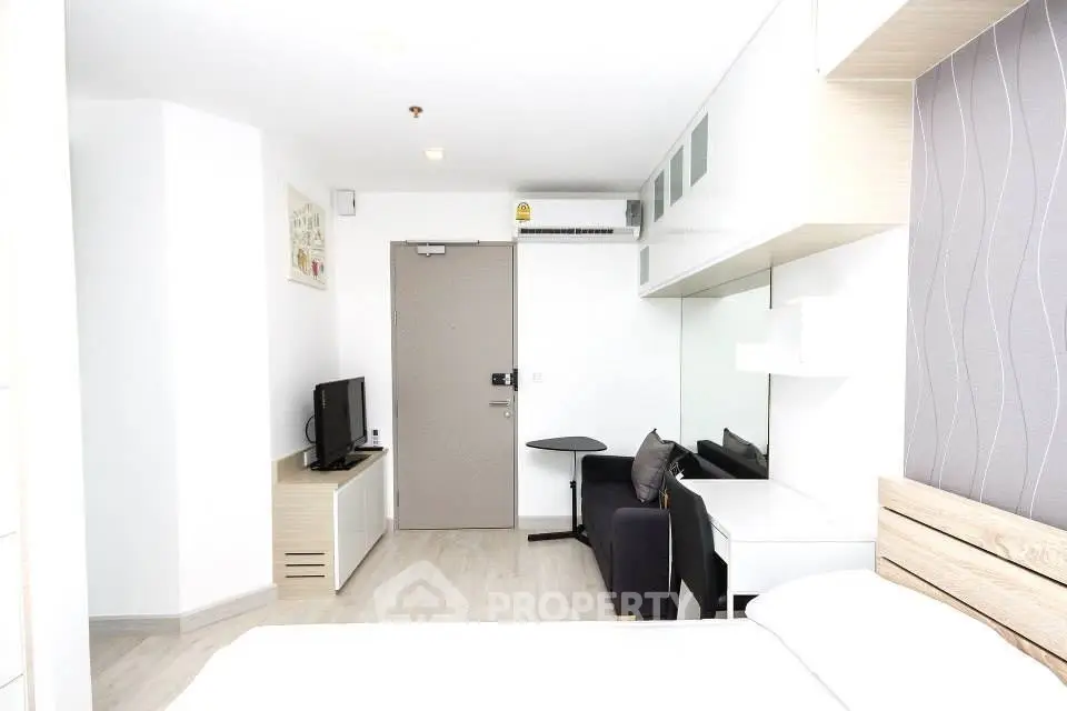 Modern studio apartment with sleek design and ample natural light, featuring a cozy living area and stylish furnishings.