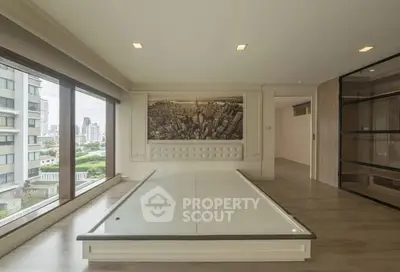 Spacious modern living room with large windows and cityscape artwork, offering stunning urban views.