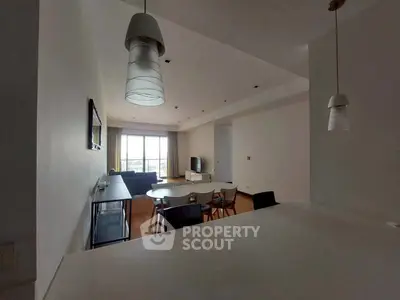 Spacious living room with modern lighting and large window view