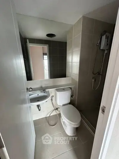 Modern bathroom with sleek fixtures and neutral tiles in a contemporary apartment.