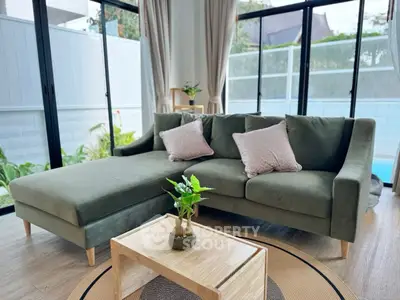 Stylish living room with green sofa and pool view, perfect for relaxation.