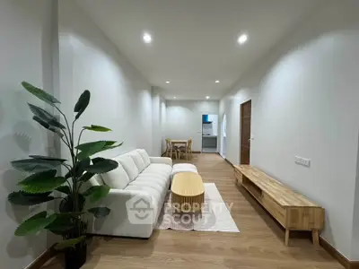 Modern living room with cozy white sofa and stylish wooden furniture in open layout apartment.
