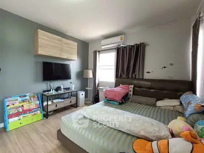 Cozy bedroom with modern decor, featuring a wall-mounted TV and ample natural light.